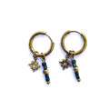 Boucles d’oreilles créoles dorées en acier inoxydable avec étoile et perles en verre bleu-vert sur fond blanc