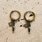 Boucles d’oreilles créoles dorées en acier inoxydable avec étoile et perles en verre bleu-vert sur fond minéral