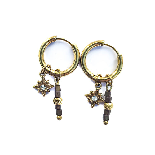 Boucles d’oreilles créoles dorées en acier inoxydable avec étoile, oxyde de zirconium et perles en verre aux tons brun rosé sur fond blanc