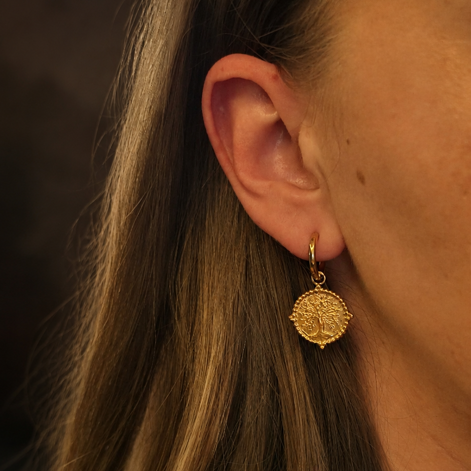 Boucles d’oreilles dorées arbre de vie portées à l’oreille