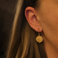 Boucles d’oreilles dorées arbre de vie portées à l’oreille