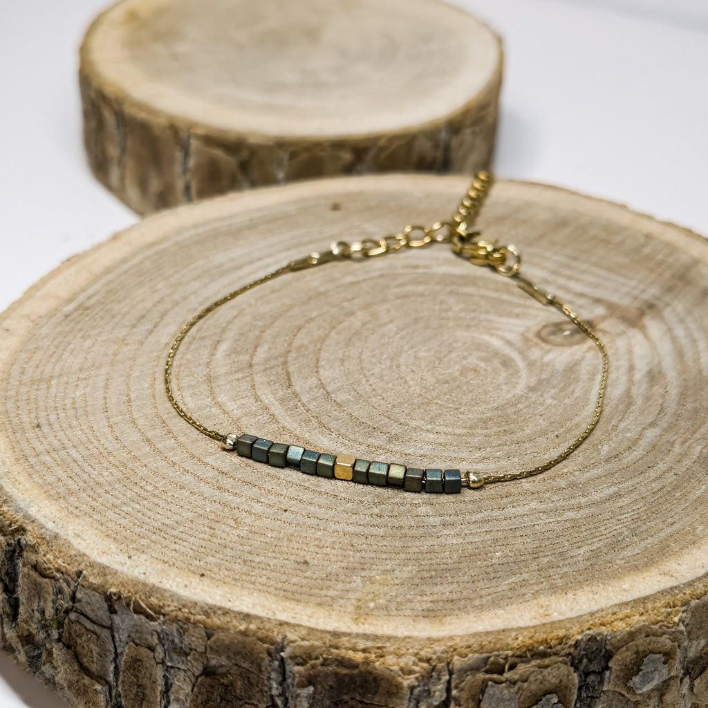 Bracelet doré en acier inoxydable décoré de perles en verre irisées vert-bleu, bijou raffiné et minimaliste Clyvia Bijoux.