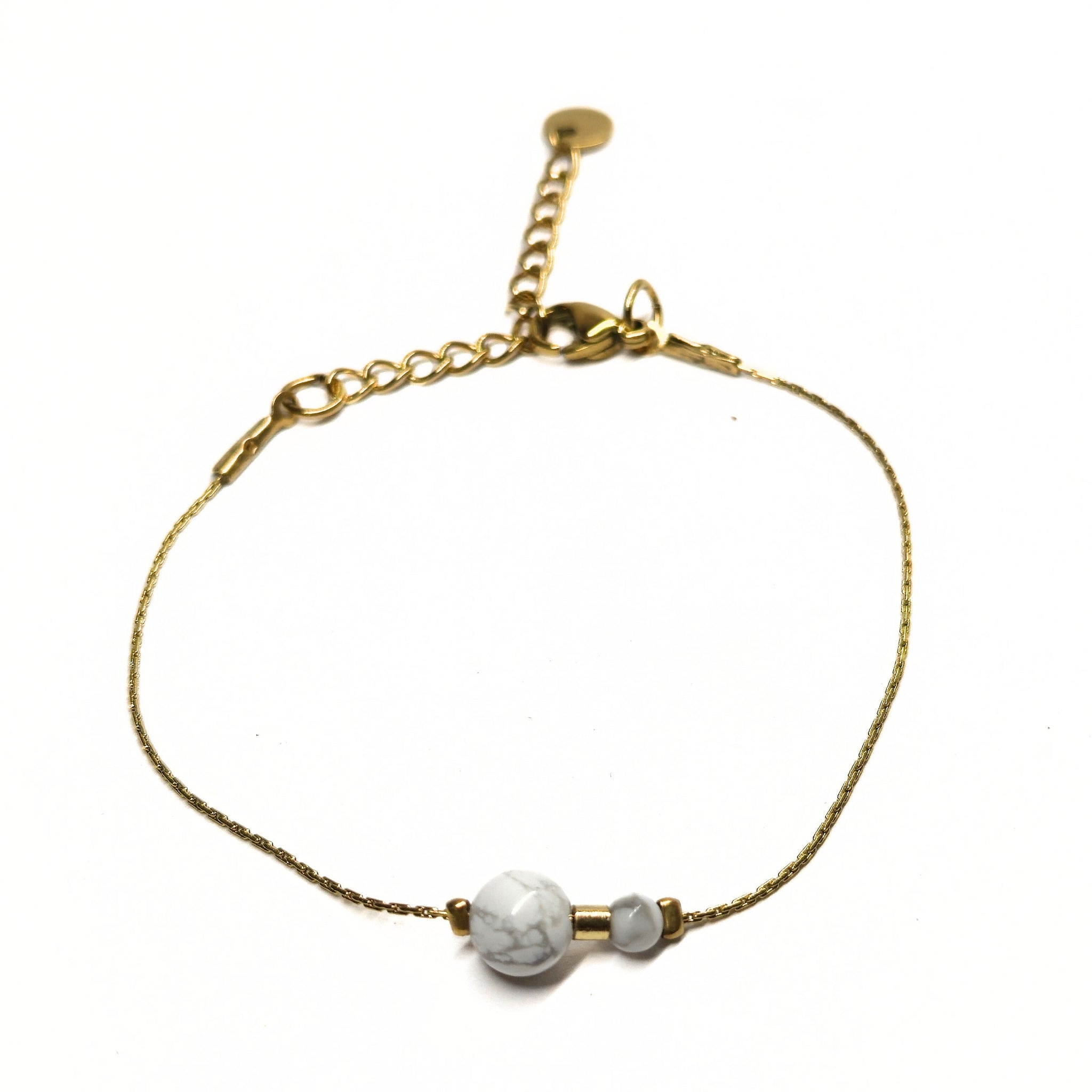 Bracelet doré en acier inoxydable avec deux perles de howlite blanche, bijou minimaliste et raffiné Clyvia Bijoux.