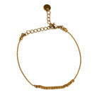 Bracelet doré fin avec perles carrées et chaîne réglable sur fond blanc