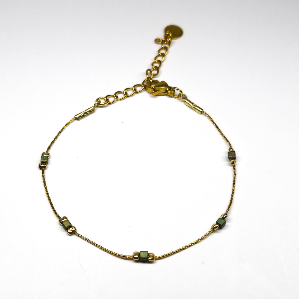 Bracelet fin doré en acier inoxydable avec petites perles irisées vert-bleu, bijou délicat et lumineux signé Clyvia Bijoux.