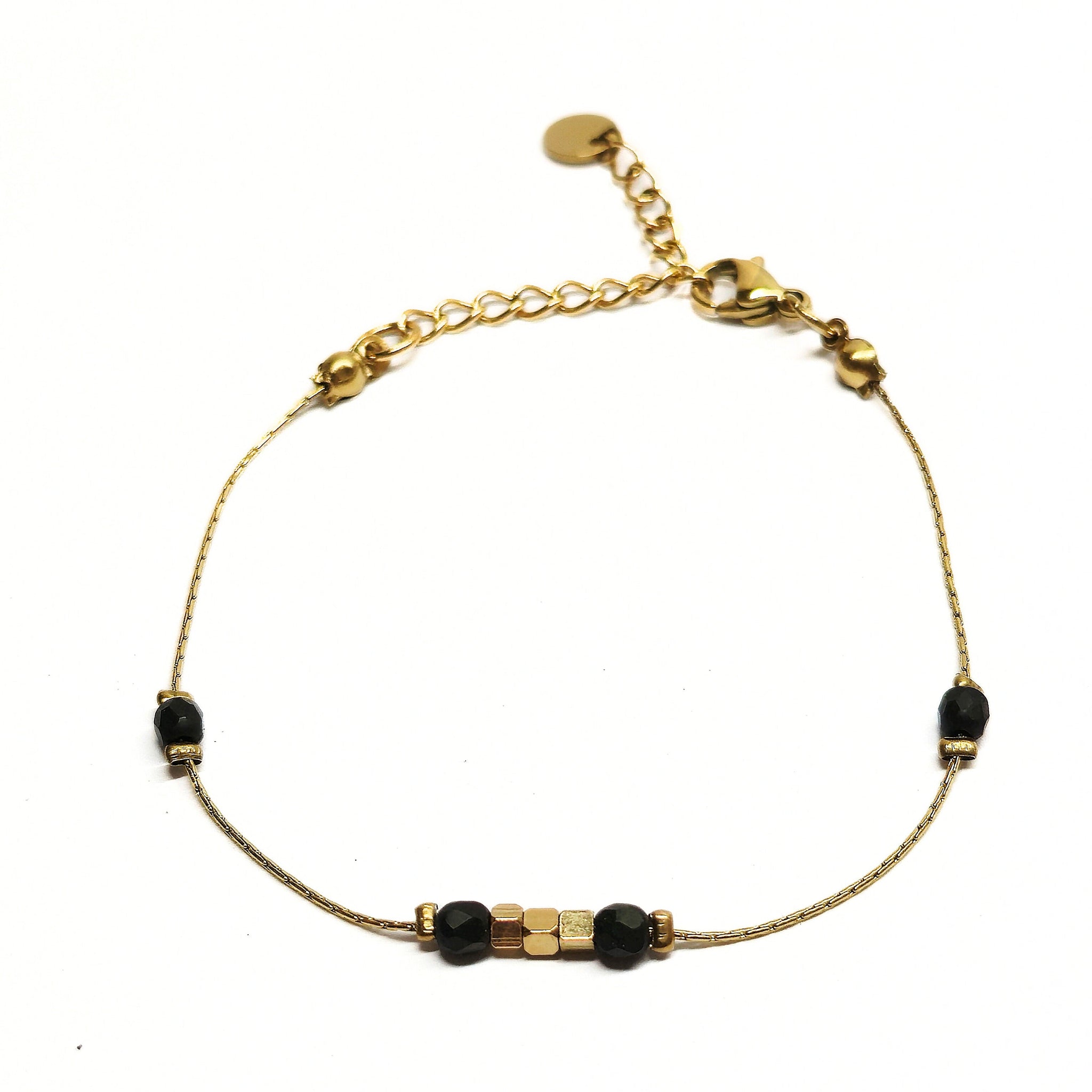 Bracelet fin doré en acier inoxydable décoré de perles noires et dorées, bijou minimaliste et chic signé Clyvia Bijoux.