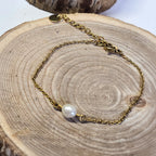Bracelet fin en acier inoxydable doré avec véritable perle d’eau douce sur support bois - Clyvia Bijoux
