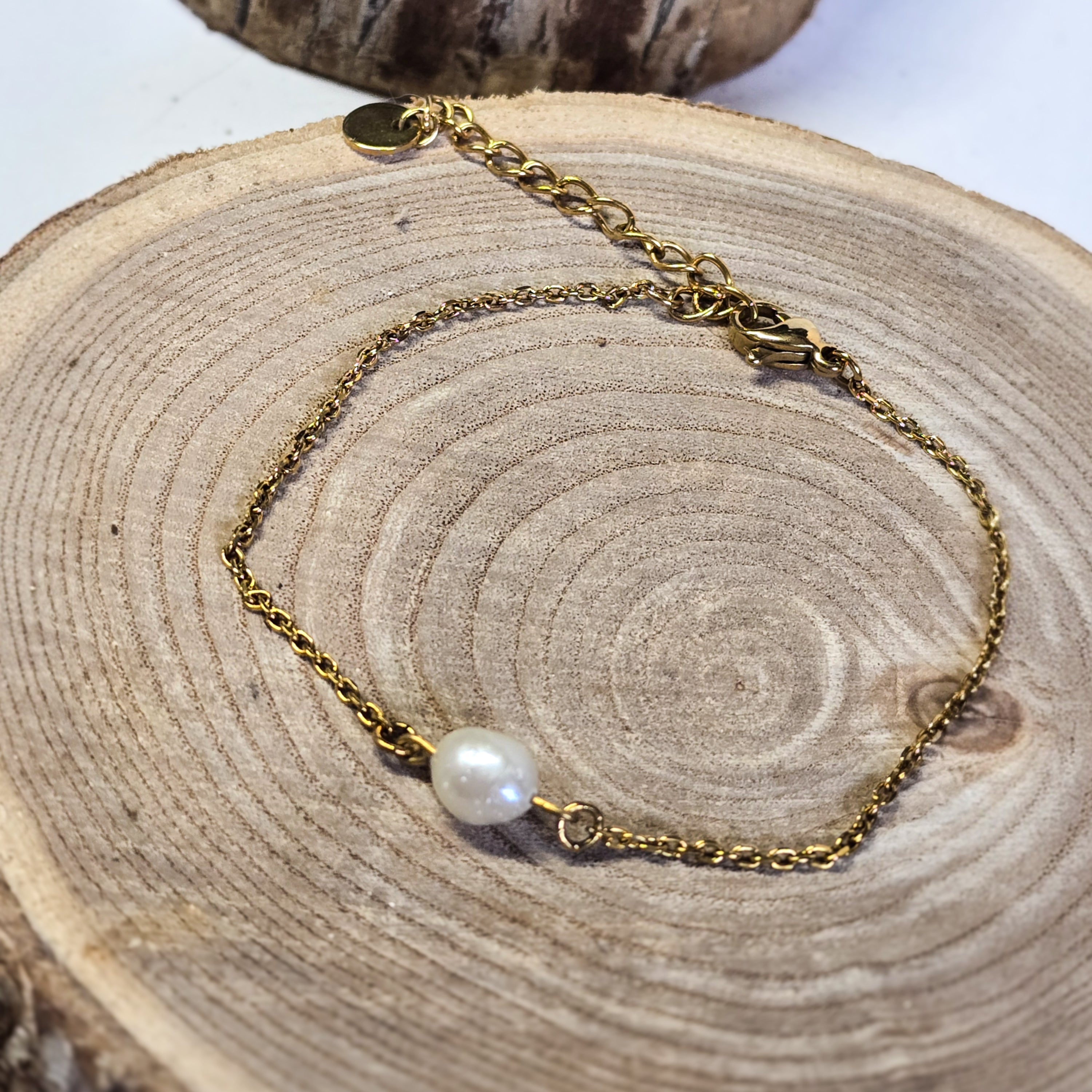 Bracelet fin en acier inoxydable doré avec véritable perle d’eau douce sur support bois - Clyvia Bijoux