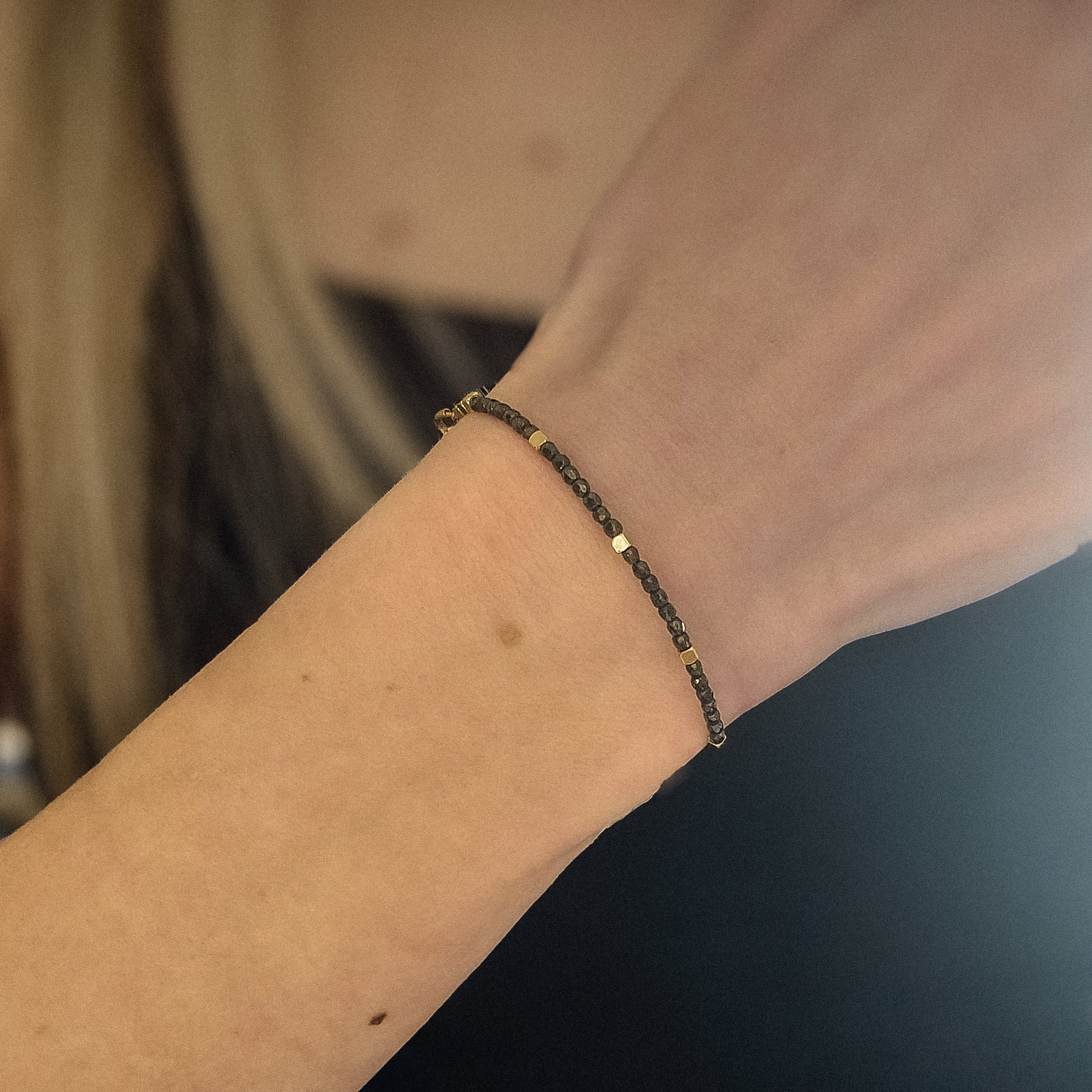 Bracelet fin en acier inoxydable avec petites perles de verre noires, porté, Clyvia Bijoux