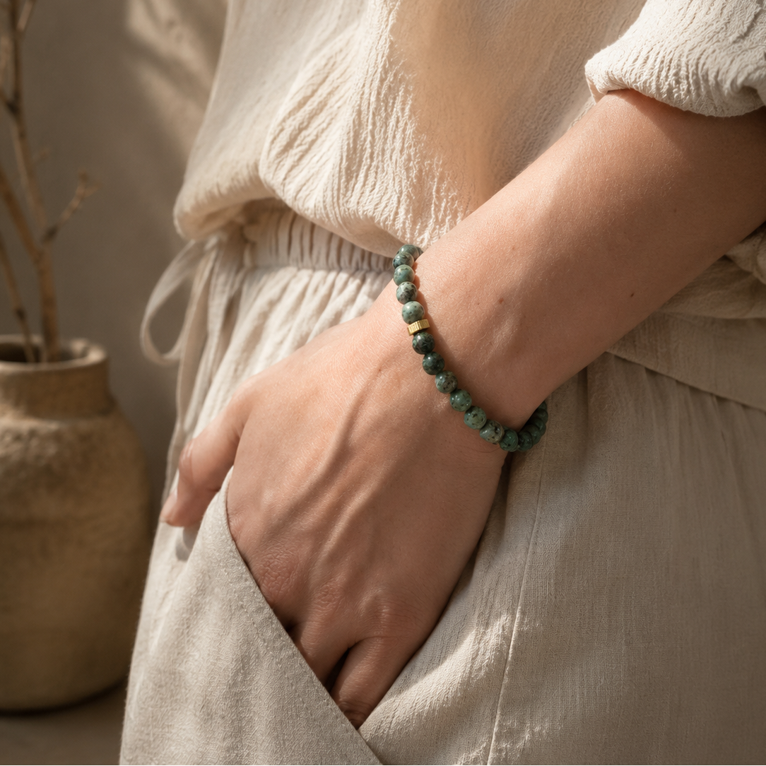 Bracelet en jaspe turquoise africaine porté au poignet avec perles vertes naturelles et détail doré.