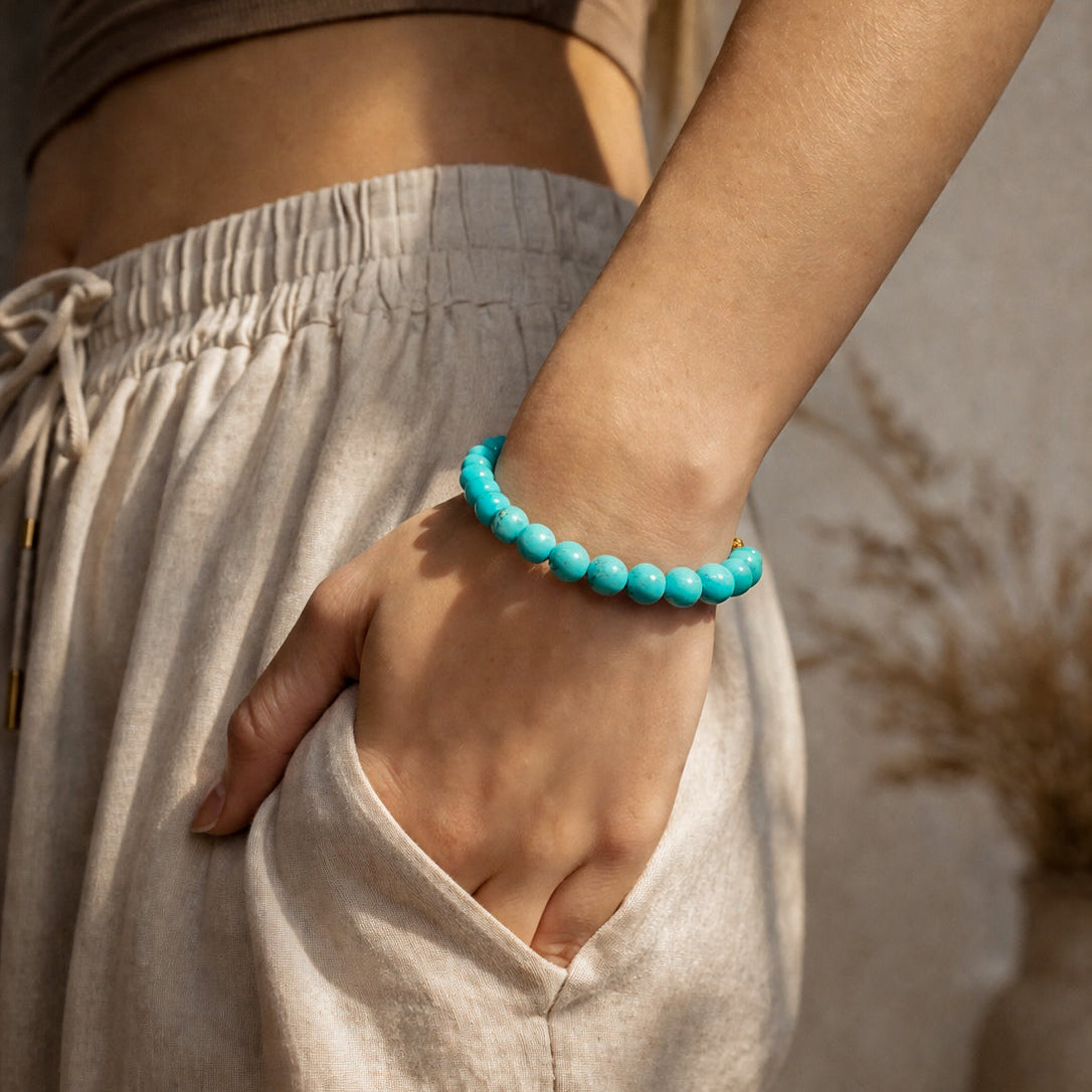 Bracelet Nahil en magnésite teintée turquoise et acier inoxydable doré porté au poignet