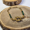 Bracelet en acier inoxydable doré et pierre malachite avec fermoir rond sur support bois - Clyvia Bijoux