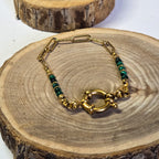 Bracelet en acier inoxydable doré et pierre malachite avec fermoir rond sur support bois - Clyvia Bijoux