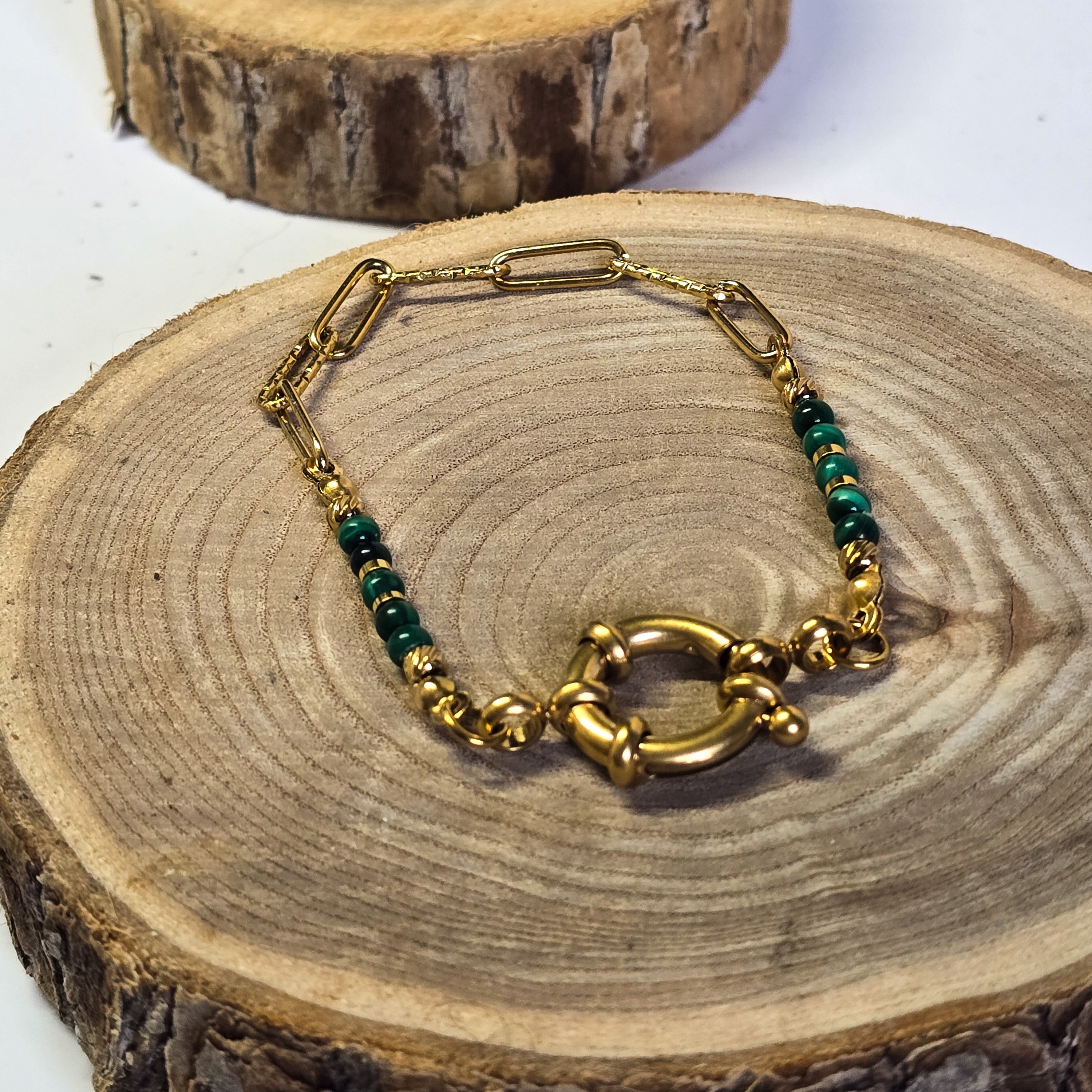 Bracelet en acier inoxydable doré et pierre malachite avec fermoir rond sur support bois - Clyvia Bijoux