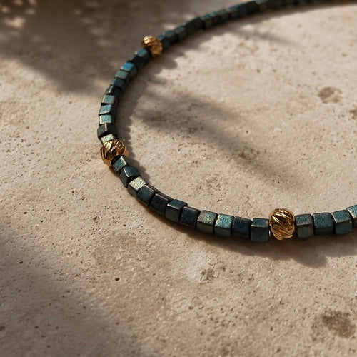 Détail du bracelet fin avec perles Miyuki bleu-vert irisées et apprêts dorés