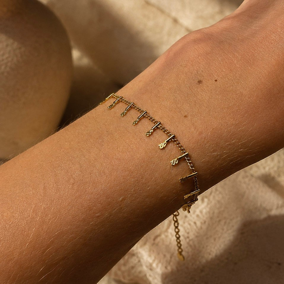 Bracelet fin Orelk en acier inoxydable doré porté au poignet