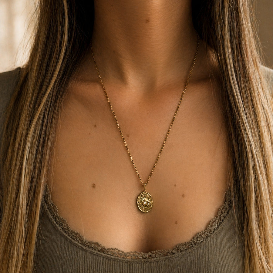 Collier long doré SOLYR avec pendentif ovale soleil porté