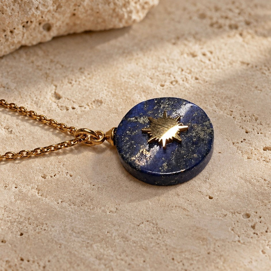 Collier doré avec pendentif soleil en lapis-lazuli dans un décor naturel