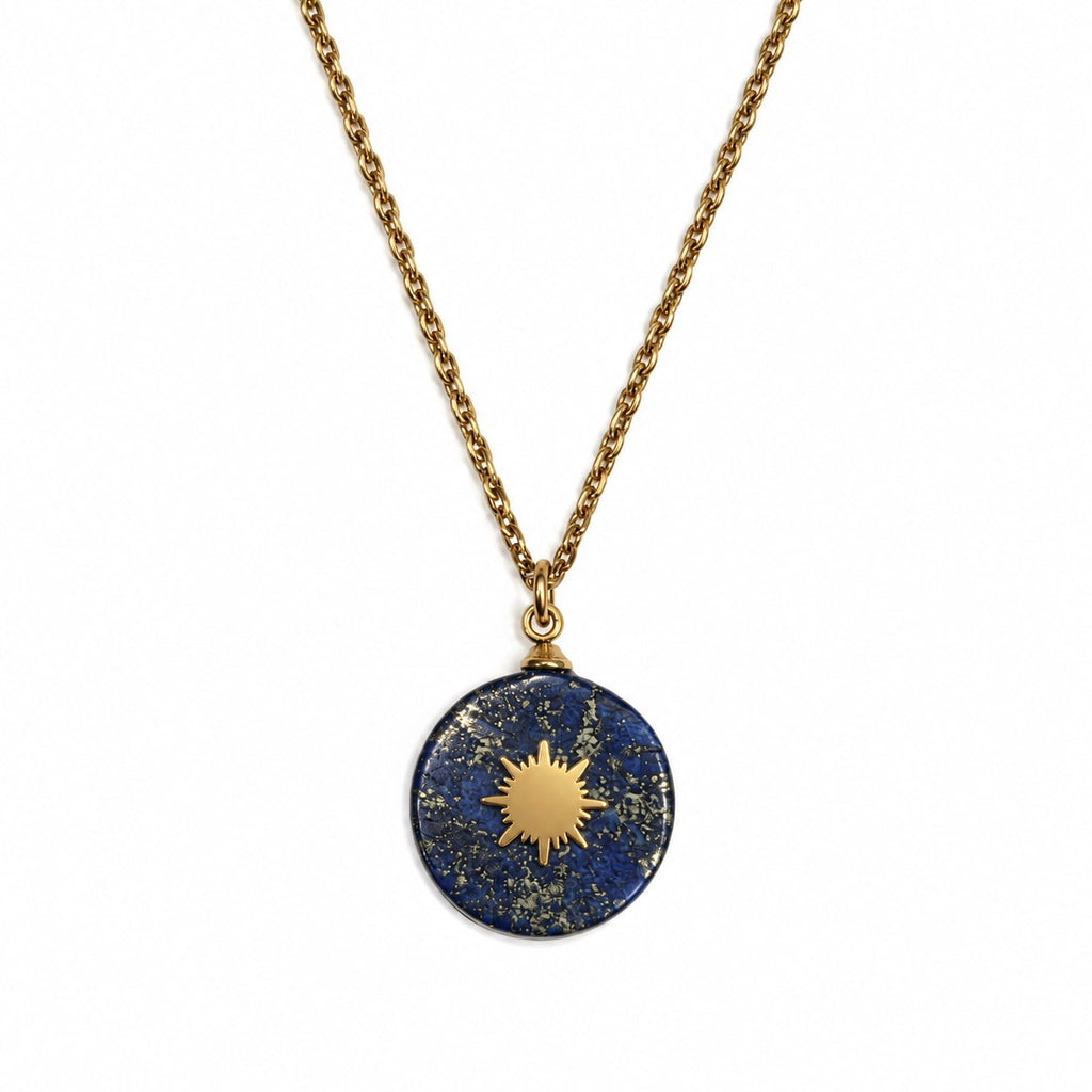 Collier long doré avec pendentif soleil en lapis-lazuli sur fond blanc