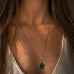 Collier long pendentif soleil en turquoise africaine porté avec chaîne dorée