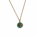 Collier long doré avec pendentif soleil en jaspe turquoise africaine sur fond blanc