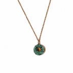 Collier long doré avec pendentif soleil en jaspe turquoise africaine sur fond blanc