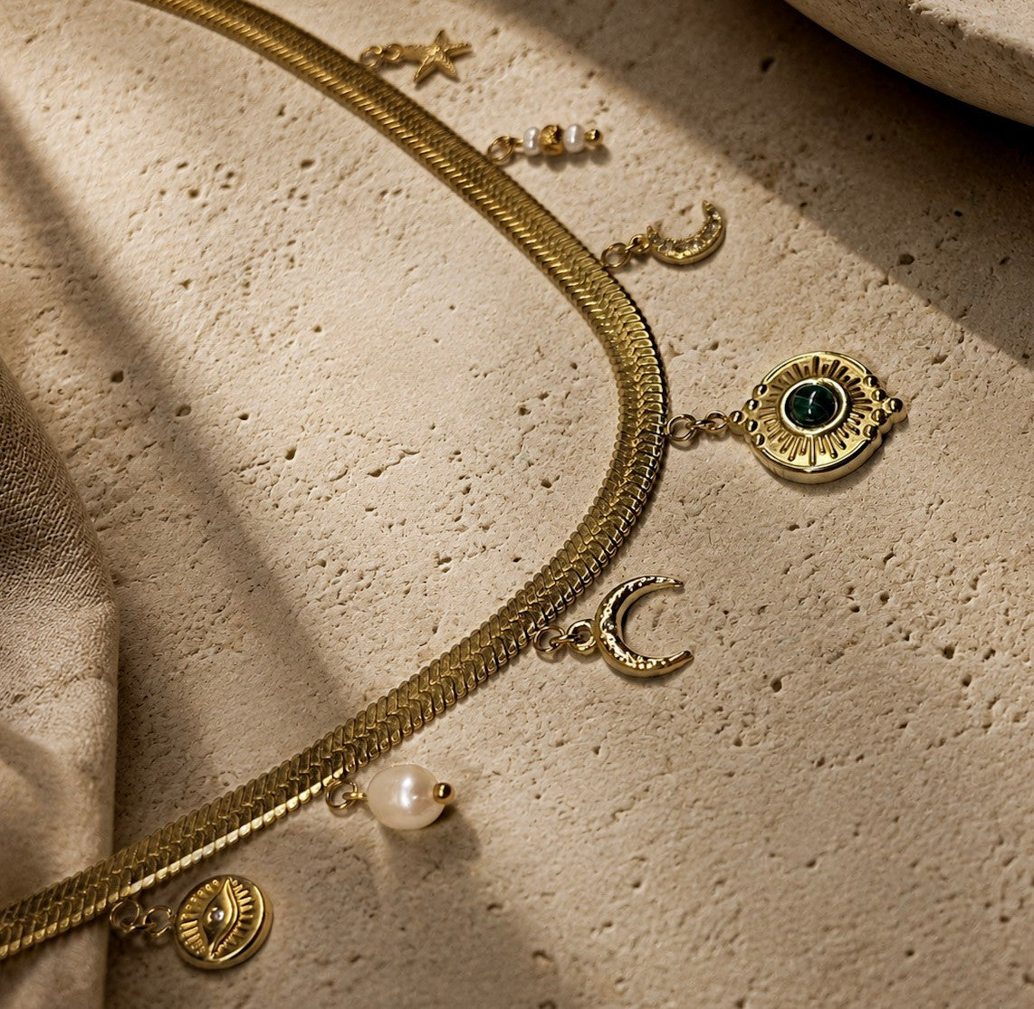  Détail d’un collier chaîne plate dorée avec malachite et perles d’eau douce