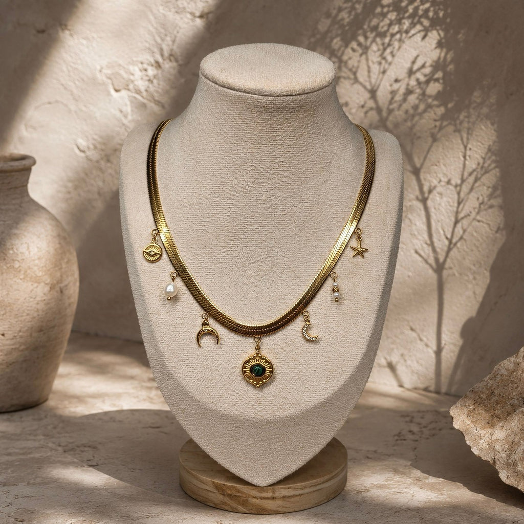 Collier chaîne plate dorée à pampilles célestes et malachite présenté sur un buste