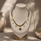 Collier chaîne plate dorée à pampilles célestes et malachite présenté sur un buste