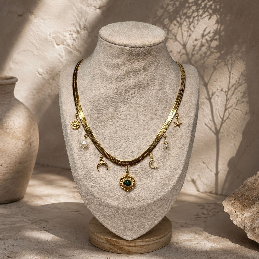 Collier chaîne plate dorée à pampilles célestes et malachite présenté sur un buste