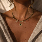 Collier doré à chaîne plate avec malachite et perles d’eau douce porté au cou