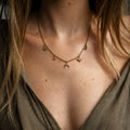 Collier fin doré à breloques porté au cou avec pendentifs symboliques en acier inoxydable