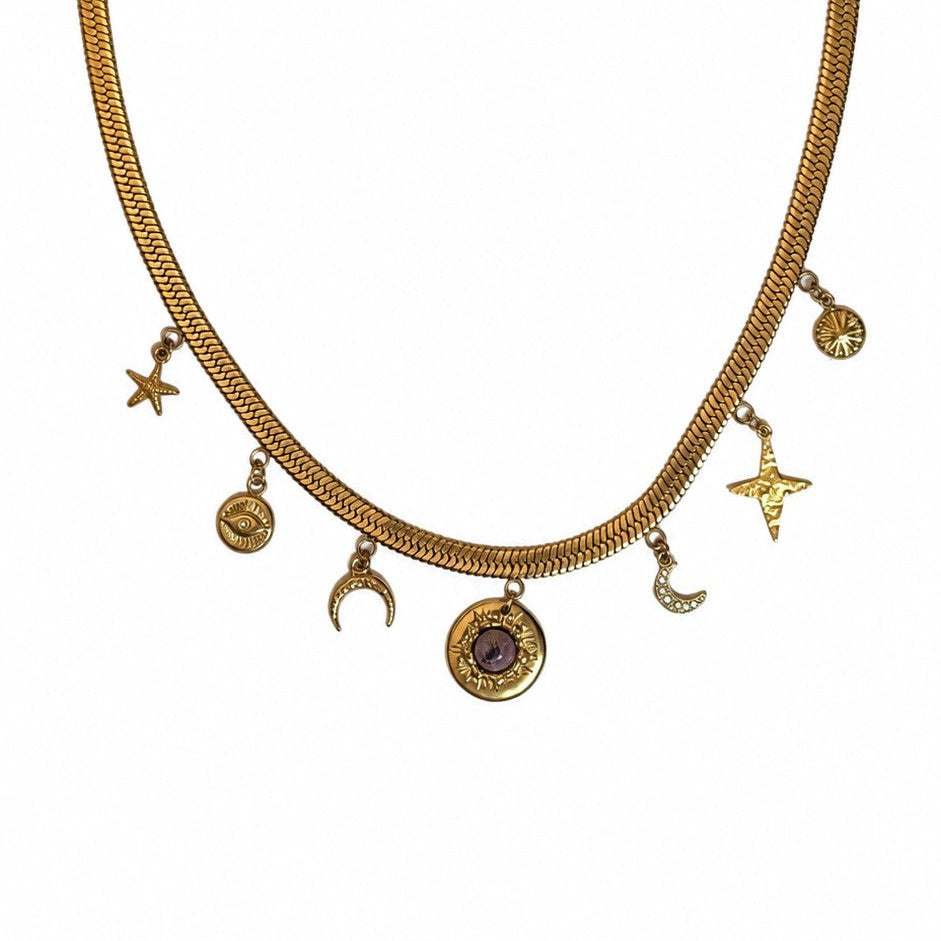 Collier doré à chaîne plate avec breloques célestes étoile, lune, oeil et pendentif pierre rose sur fond blanc