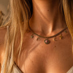 Collier doré femme porté au cou avec chaîne plate et breloques étoile, lune, oeil et pierre rose