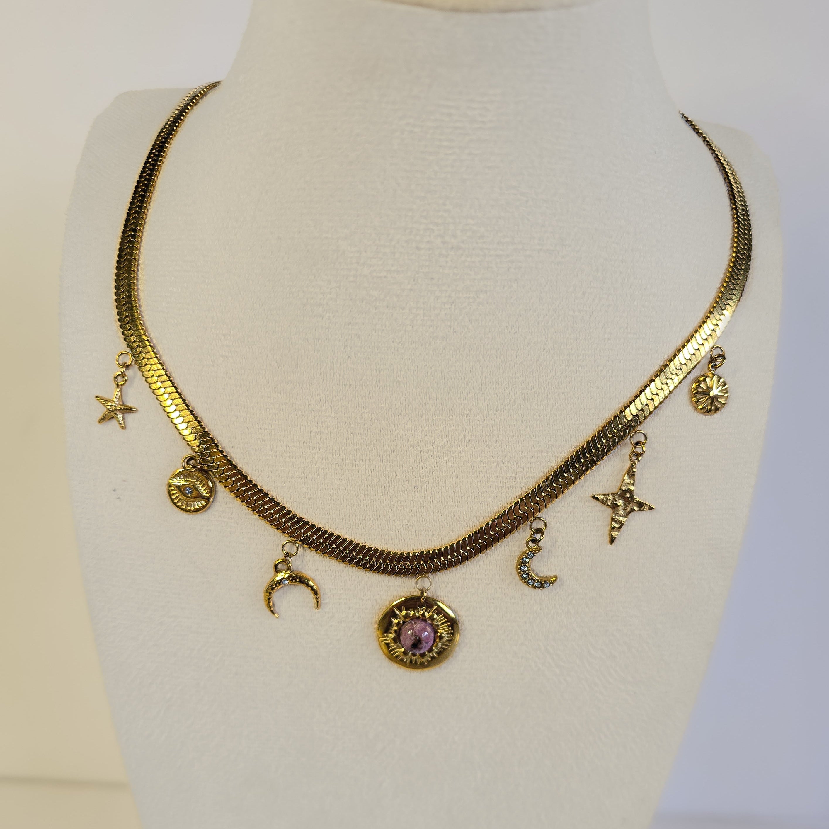 Collier doré en acier inoxydable à chaîne plate avec charms et rhodonite porté, Clyvia Bijoux.