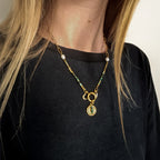 Collier doré avec jaspe turquoise africain, perles blanches et médaille œil, porté, Clyvia Bijoux