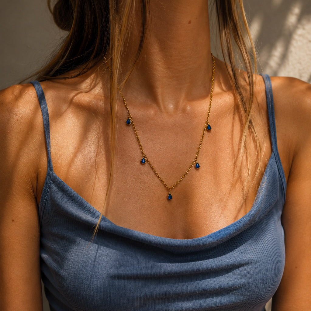 Collier doré en acier inoxydable porté avec pampilles en lapis lazuli bleu
