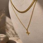 Collier doré à pendentif étoile présenté sur un buste avec une chaîne plate assortie.