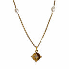 Collier doré avec pendentif étoile serti et perles blanches sur fond blanc