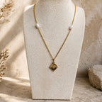 Collier doré avec pendentif étoile et perles blanches présenté sur buste