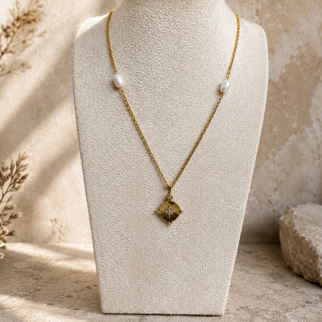 Collier doré avec pendentif étoile et perles blanches présenté sur buste