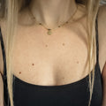 Collier doré avec perles bleu-vert irisées et médaille œil, porté près du cou, Clyvia Bijoux