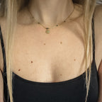 Collier doré avec perles bleu-vert irisées et médaille œil, porté près du cou, Clyvia Bijoux