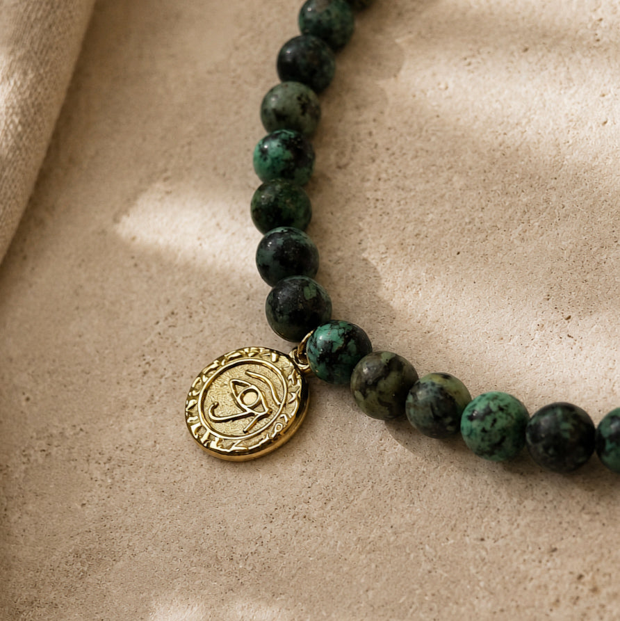 Détail du collier en jaspe turquoise africain et de sa médaille œil dorée