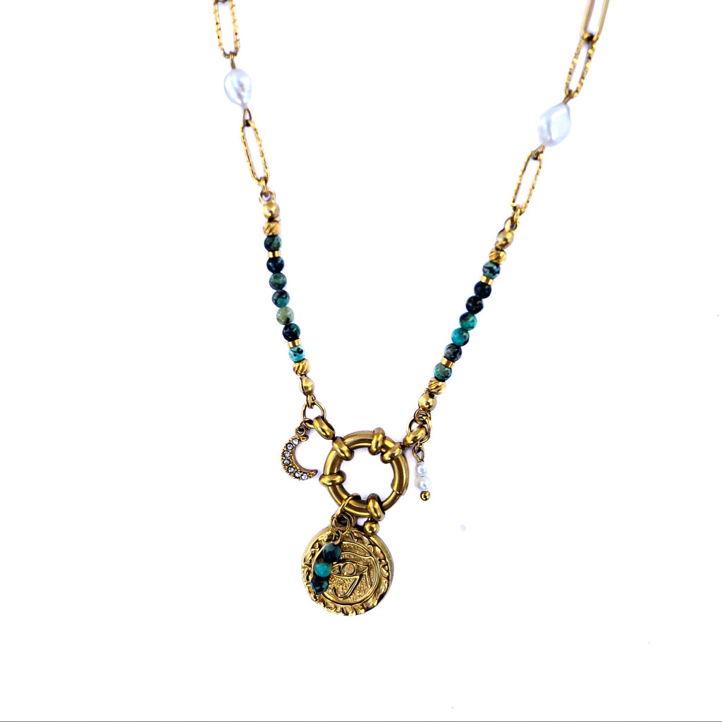 Collier doré avec jaspe vert, perles blanches et pendentif œil sur fond clair