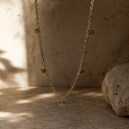 Détail des pampilles rondes martelées d’un collier long doré