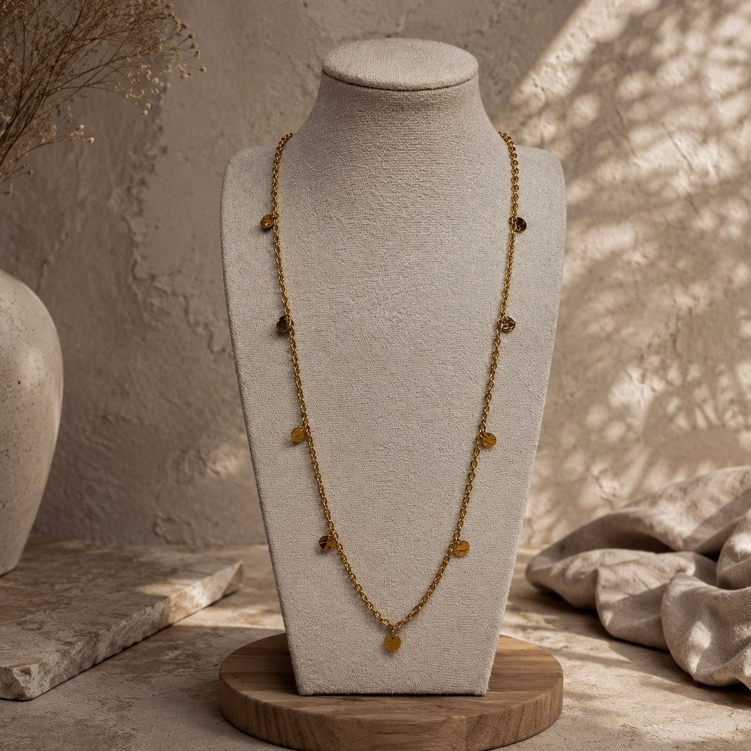 Collier long doré à petites pampilles rondes présenté sur un buste