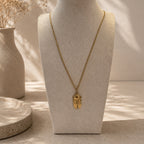 Collier long doré avec pendentif cigale sur buste beige, bijou inspiré de la Provence
