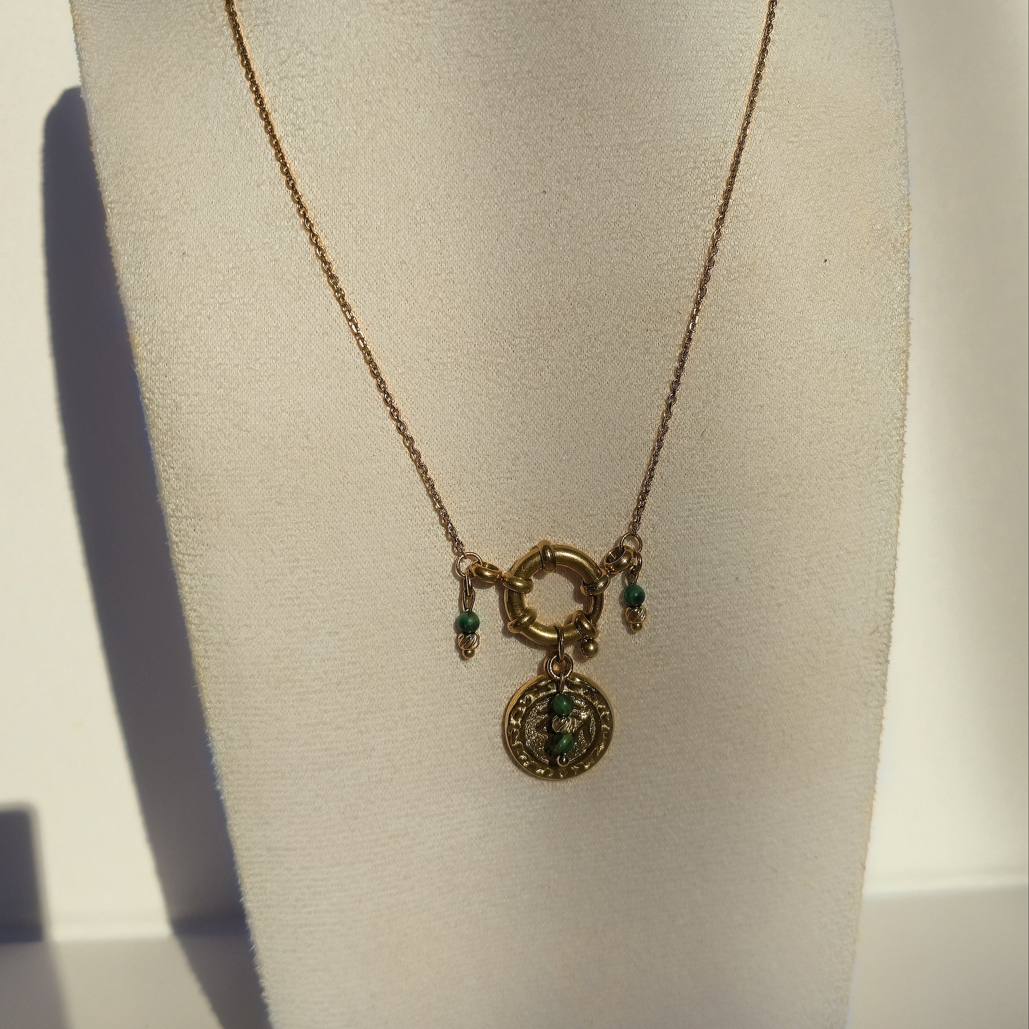 Collier long doré avec pendentif œil et malachites naturelles présenté sur buste