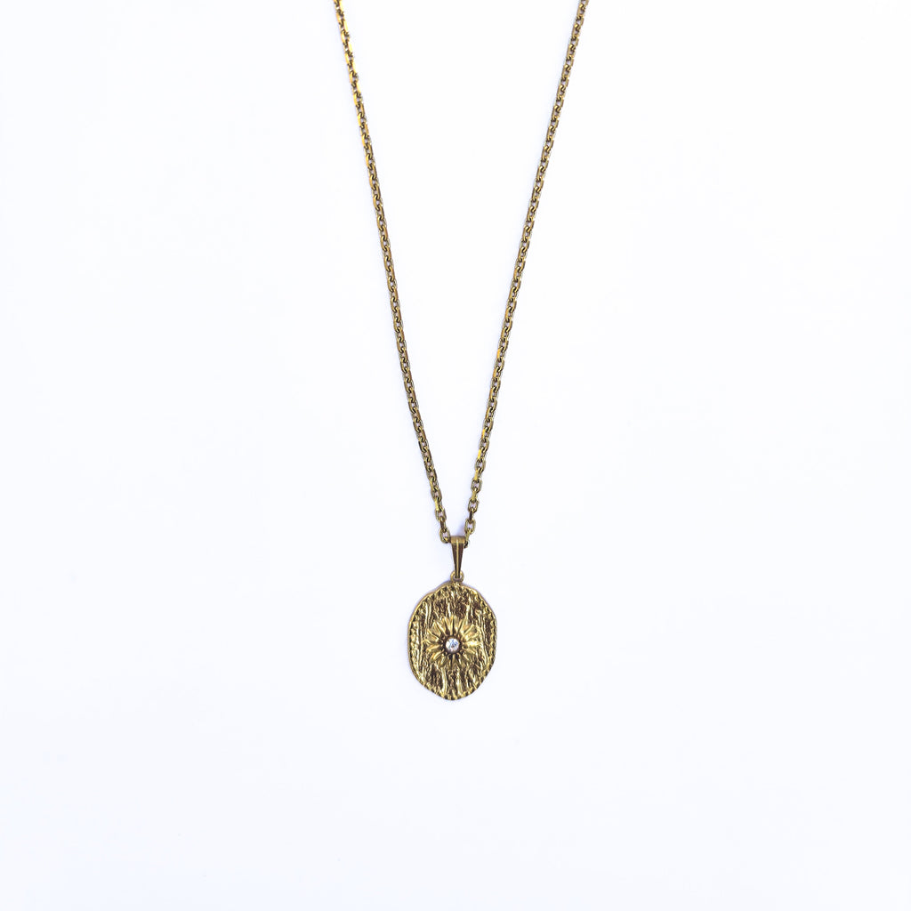 Collier long doré en acier inoxydable avec pendentif ovale soleil et oxyde de zirconium sur fond blanc